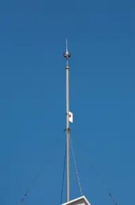 A large lightning rod on top of a roof.