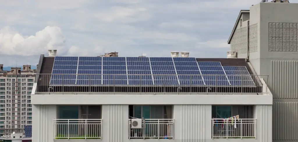 Solar panels are installed on the roof of an apartment building.
