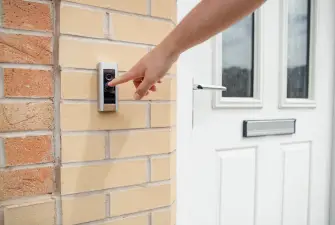A man pressing the button on a Ring video doorbell but discovering the Ring Solar Panel Is Not Working.