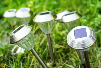 Seven small solar lights in the grass about to be stored away safely.